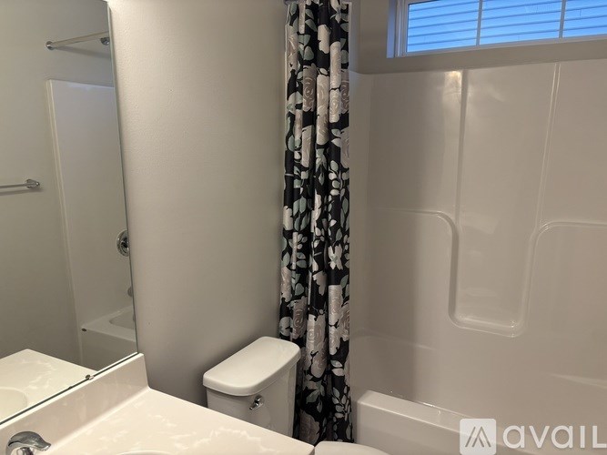 A white toilet sits next to a white bathtub in a bathroom.