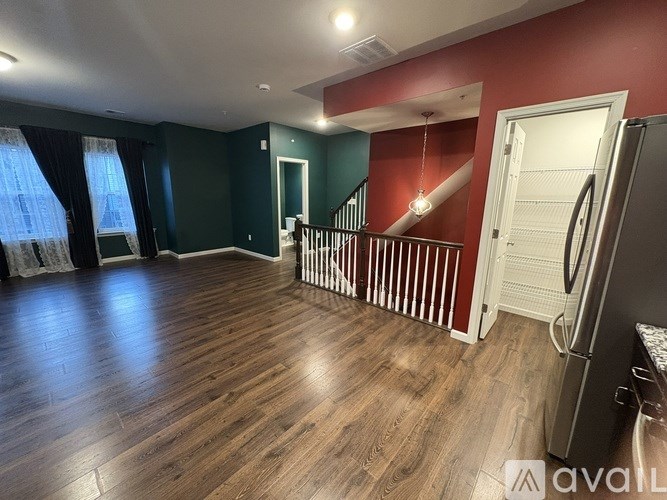 A spacious room with a staircase and a refrigerator.