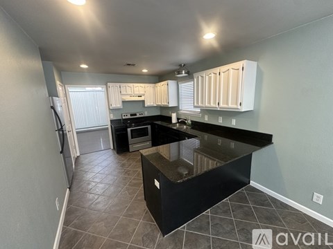 A kitchen with black countertops and white cabinets.