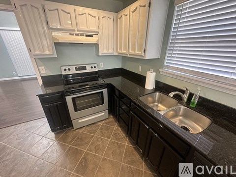 A kitchen with black countertops and white cabinets.