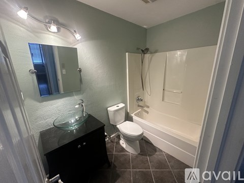 A bathroom with a toilet, sink, and bathtub.