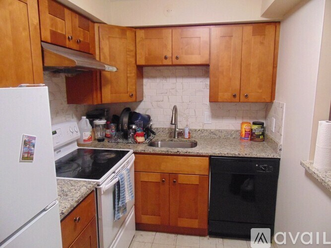 A kitchen with wooden cabinets and a white fridge.