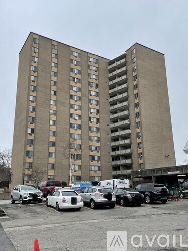 A tall building with a parking lot in front of it.