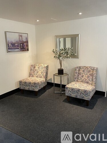 Two chairs and a table with a vase of flowers on it.