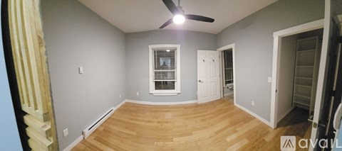 A room with wooden floors and a window with a white frame.