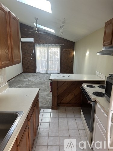 A kitchen with wooden cabinets and a stove top oven.