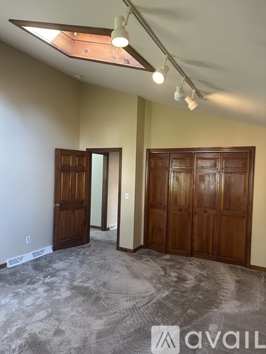 A room with a carpeted floor and a wooden door.