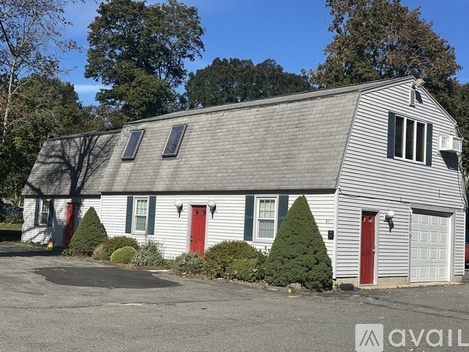 A house with a grey roof and a red door is for sale.