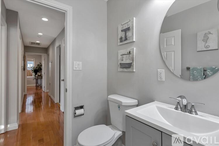 A bathroom with a toilet, sink, and mirror.