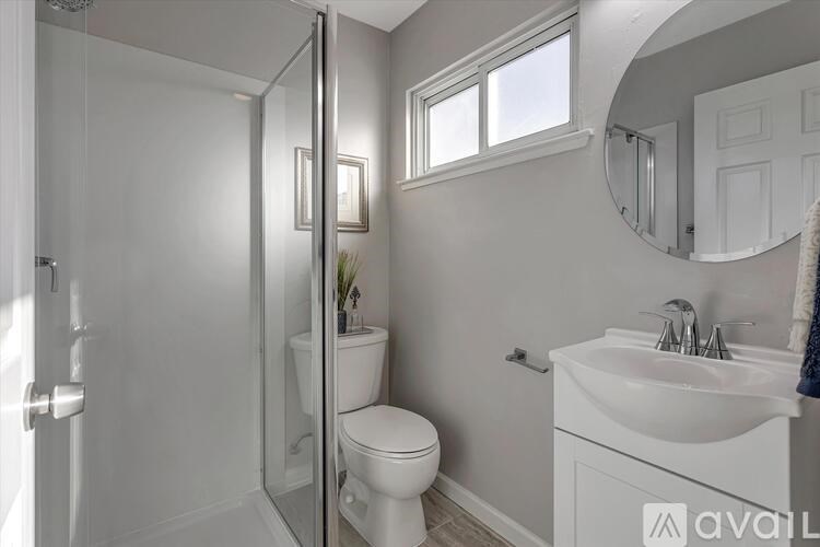 A bathroom with a toilet, sink, and mirror.