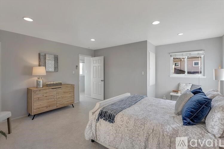A bedroom with a bed, dresser, and window.