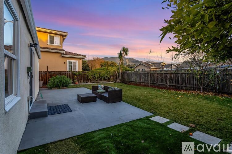 A backyard with a patio and a fence.