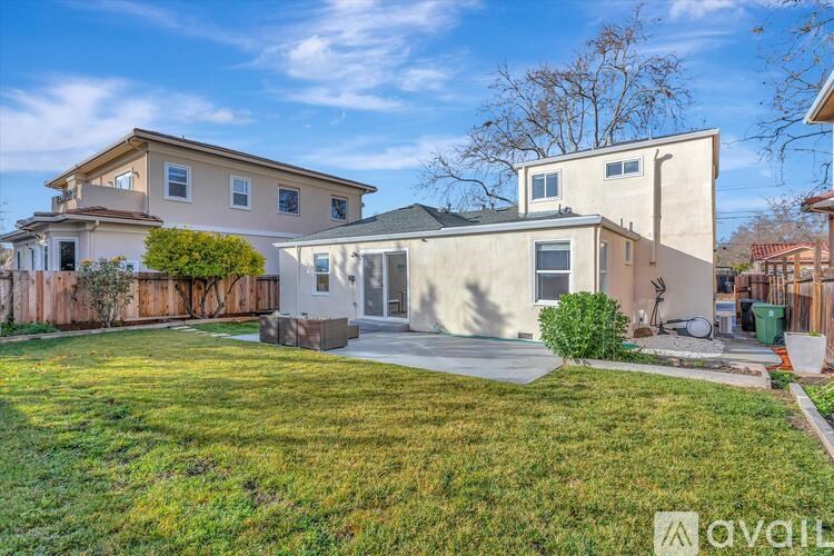 A house with a well-maintained lawn and a clear sky above.