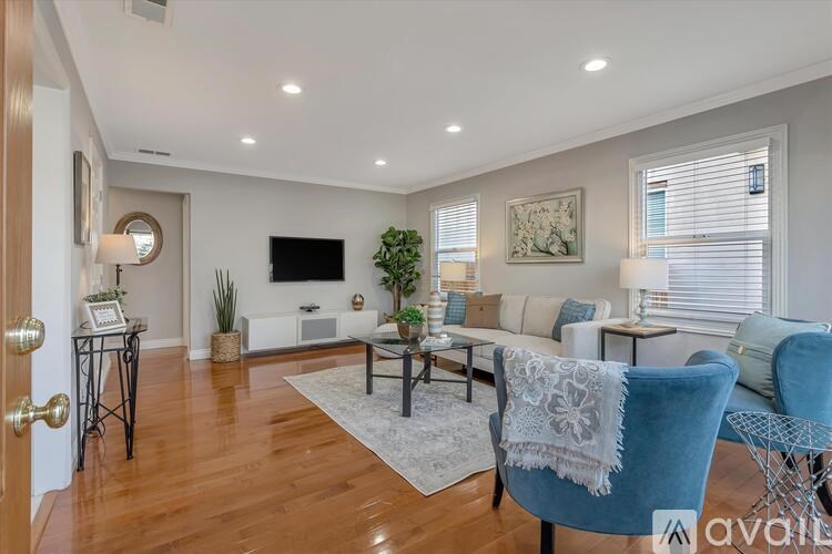 A living room with a blue chair and a white couch.