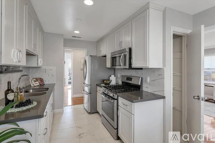 A kitchen with white cabinets and stainless steel appliances.