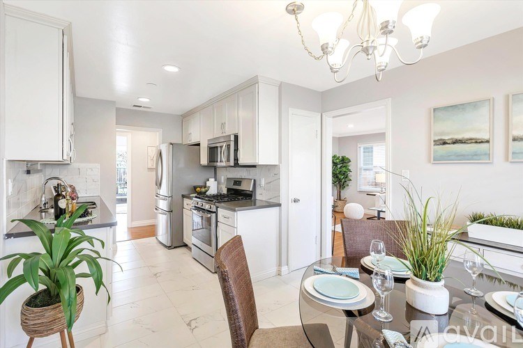 A modern kitchen with a dining table set for two.