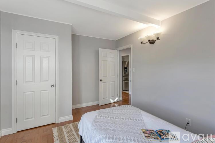 A bedroom with a bed, two doors, and a ceiling light.