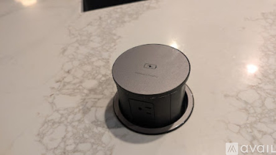 A black speaker is sitting on a marble surface.