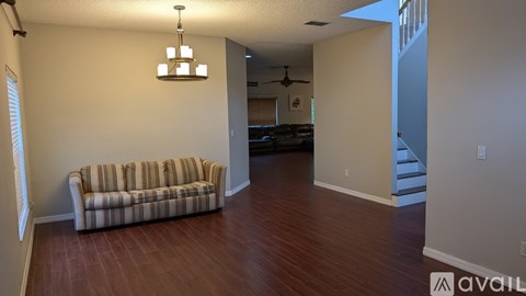 A living room with a striped couch and a chandelier.