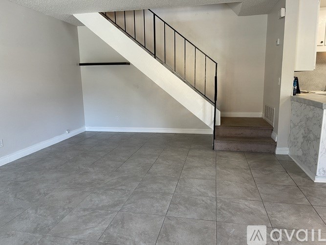 A spacious room with a marble counter and a staircase.