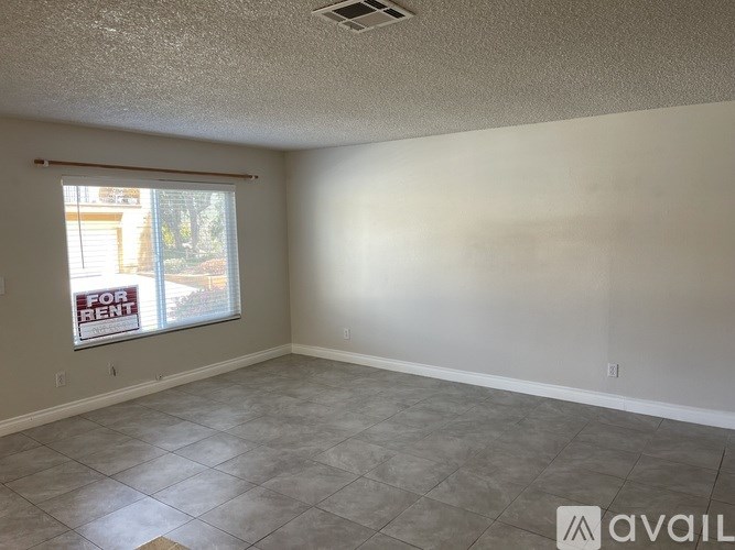 A room with a "For Rent" sign in the window.