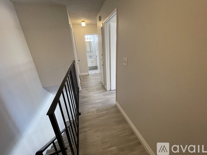 A hallway with a staircase on the left and a doorway on the right.