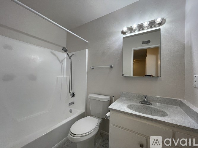 A bathroom with a toilet, sink, and bathtub.