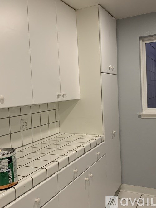 A kitchen with white cabinets and a tiled backsplash.