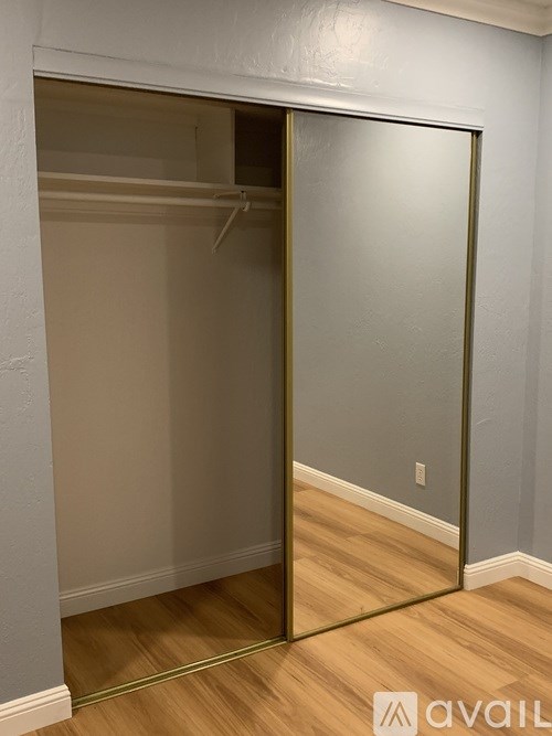 A room with a sliding door and wood flooring.