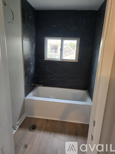 A bathroom with a tub and a window.