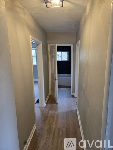 A hallway with a door on the right and a window on the left.