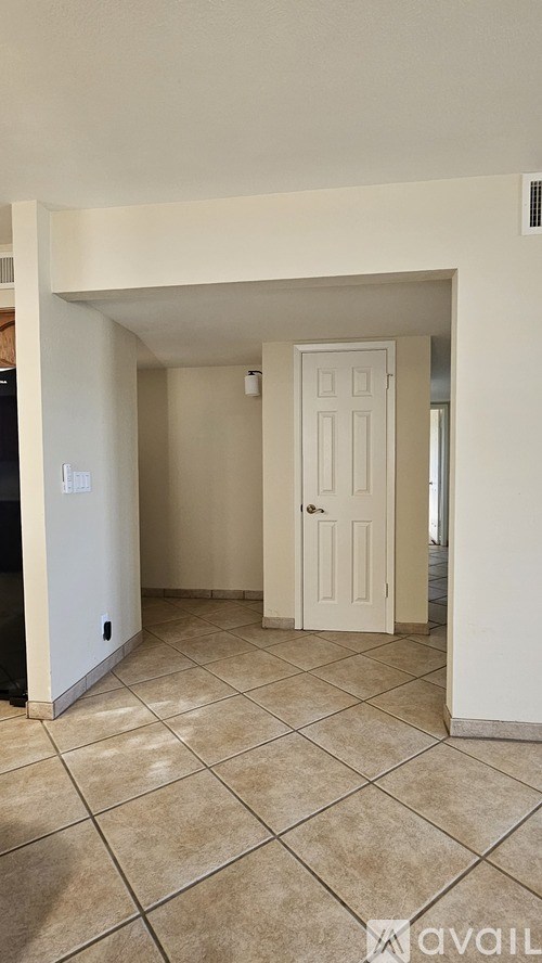 A room with a white door and tiled floor.