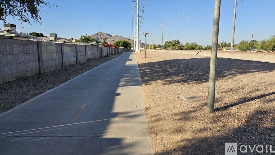 A long, empty road stretches into the distance with a clear blue sky above.