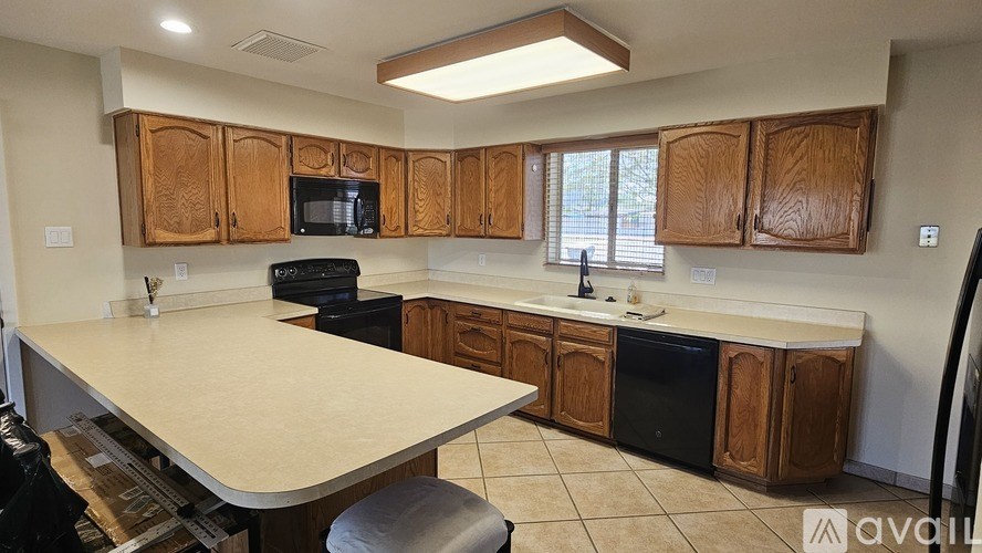 A kitchen with wooden cabinets and black appliances.