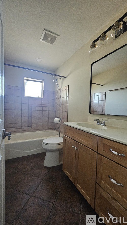 A bathroom with brown tile floors and a white toilet.