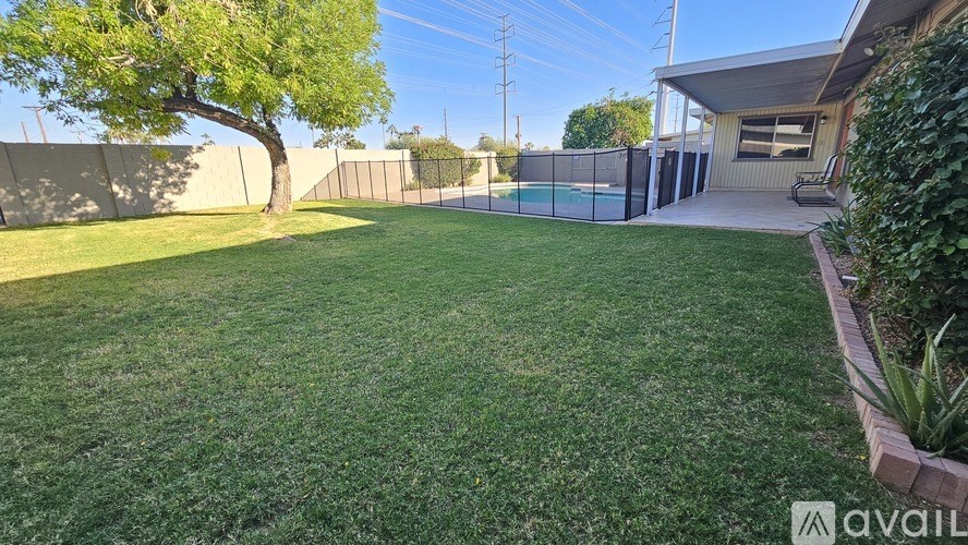A backyard with a tennis court and a fence.
