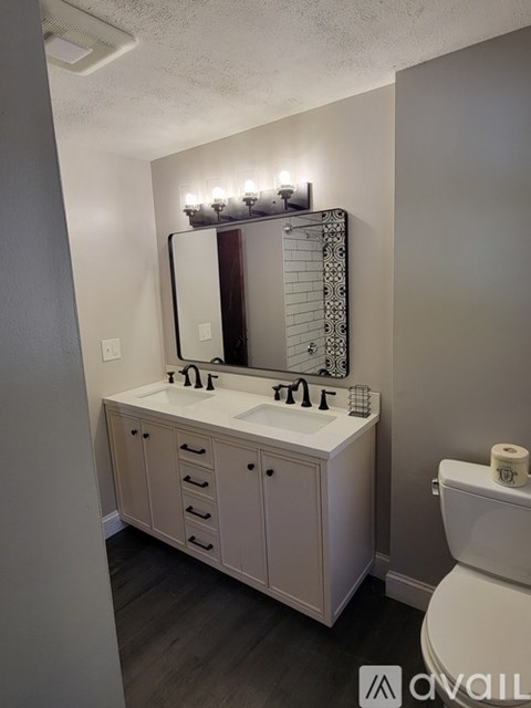 A bathroom with a white vanity and a white toilet.