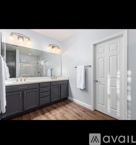 A bathroom with a double sink vanity and a large mirror.
