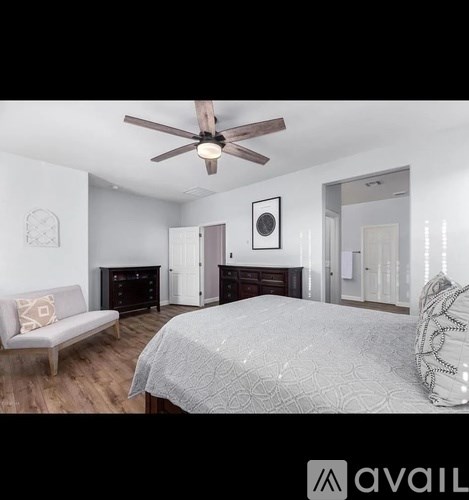 A bedroom with a bed, dresser, and couch.