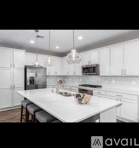 A modern kitchen with white cabinets and a large island.