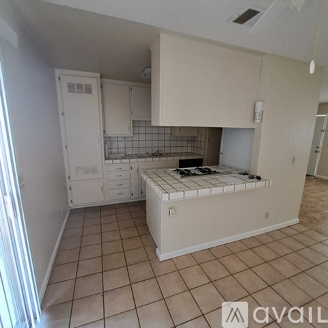 A kitchen with white cabinets and a tiled backsplash.