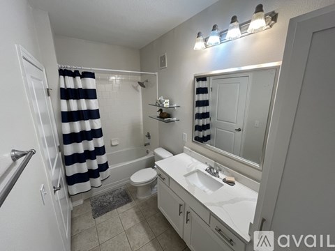 A bathroom with a striped shower curtain and a white sink.