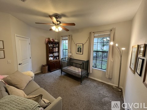 A baby's room with a crib and a fan.