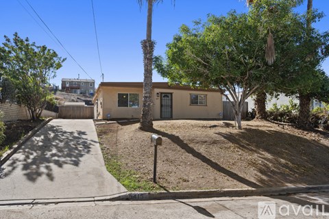 A house with a brown roof and a tree in front of it.