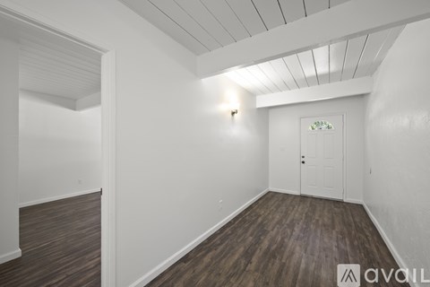 A room with a white door and a window on the wall.