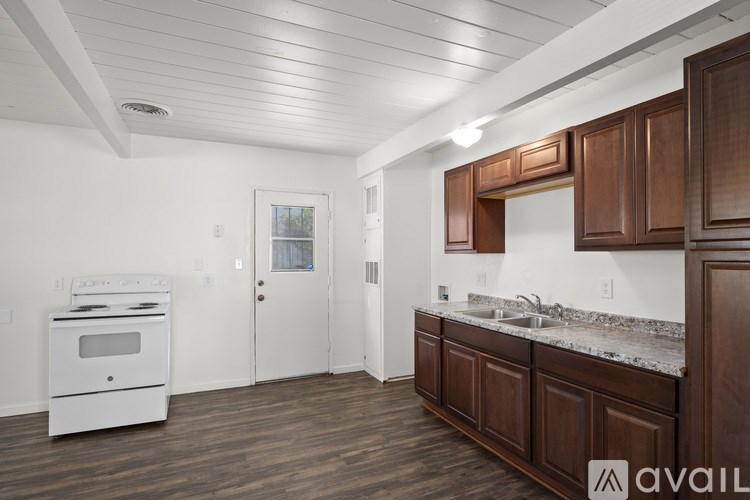 A kitchen with brown cabinets and a white oven.