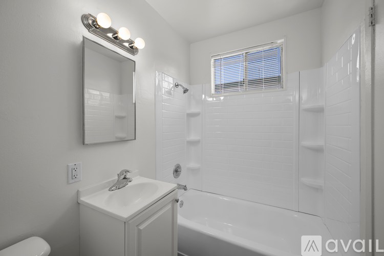 A bathroom with a white sink, mirror, and bathtub.