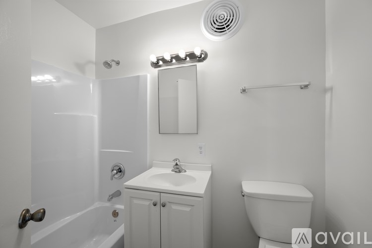 A white bathroom with a toilet, sink, and bathtub.