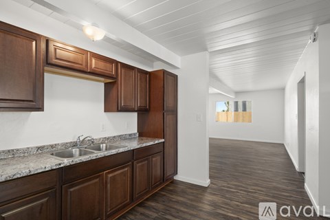 A kitchen with brown cabinets and a marble countertop.