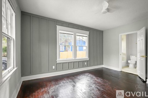 A room with a window and a fan on the ceiling.